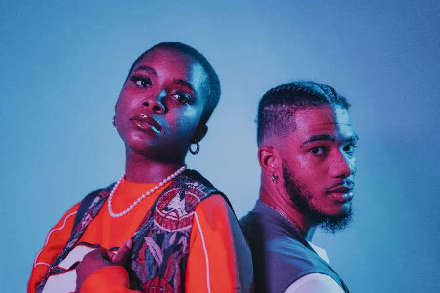 Portrait de deux créateurs de contenu sur fond bleu, style photo Instagram