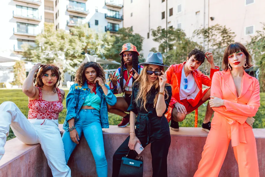 Groupe de jeunes influenceurs mode posant en tenues colorées dans la rue